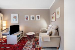 a living room with a chair and a television at Bluehome Ferienwohnung in Bad Bellingen
