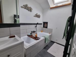 a bathroom with a tub and a sink at La Maison Neuve in Béganne +20 photos