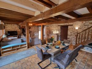 a living room with a table and some chairs at La Maison Neuve in Béganne