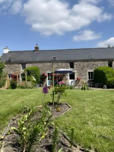 a stone house with a garden in front of it at La Maison Neuve in Béganne