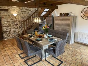 a dining room with a wooden table and chairs at La Maison Neuve in Béganne