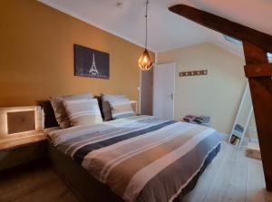 a bedroom with a large bed in a room at La Maison Neuve in Béganne