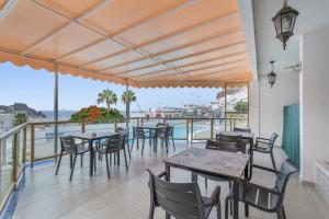 a restaurant with tables and chairs on a balcony at Vistas al atlantico in Puerto Rico de Gran Canaria