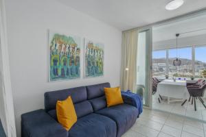 a living room with a blue couch and a table at Vistas al atlantico in Puerto Rico de Gran Canaria