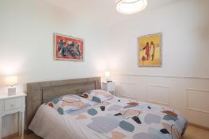 a bedroom with a bed and two pictures on the wall at T2 avec terrasse proche plages in Pléneuf-Val-André