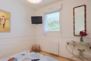 a bedroom with a bed and a window and a television at T2 avec terrasse proche plages in Pléneuf-Val-André