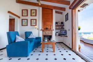 a living room with two blue chairs and a fireplace at Villa Solivent in Es Mercadal