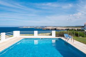 a swimming pool with a view of the ocean at Villa Solivent in Es Mercadal
