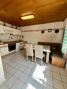 a kitchen with a table and chairs in it at Schwarzwald-Ferienwohnung Lehmann in Oppenau +5 photos