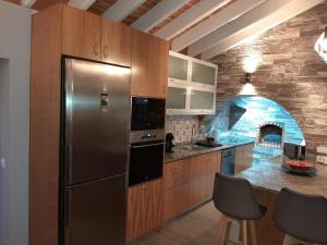 a kitchen with a stainless steel refrigerator and an oven at Casa das Cales in Angra do Heroísmo