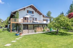 a house with a large yard in front of it at Ferienwohnung Julia in Taching am See