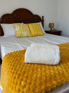 a bed with two towels on top of it at Alojamento Local Vale dos Vascos in Alvaro