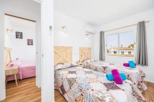 a bedroom with two beds and a window at Gran Sol Family 7 in Felanitx