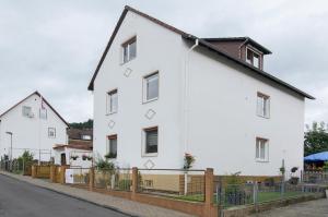 a white house with a fence in front of it at Ferienwohnung Storchenblick in Grebendorf