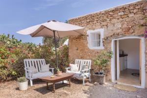 a patio with two chairs and an umbrella at Can Xicu in Illes Balears