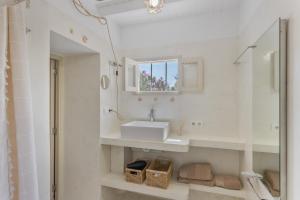 a white bathroom with a sink and a mirror at Can Xicu in Illes Balears +22 photos