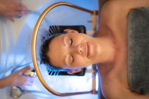 a woman is drying her hair in front of a mirror at Thermae Boetfort Hotel in Steenokkerzeel +16 photos