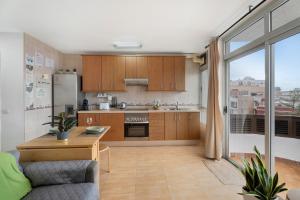 a kitchen with wooden cabinets and a large window at Vivir Bajamar in Bajamar