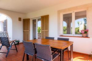 a dining room with a wooden table and chairs at Casa Inés in Cala Murada