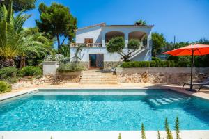 a villa with a swimming pool in front of a house at Casa Inés in Cala Murada