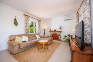 a living room with a couch and a tv at Casa Inés in Cala Murada