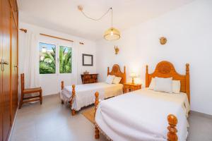 a bedroom with two beds and a window at Casa Inés in Cala Murada +36 photos