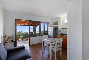 a kitchen and a living room with a table and chairs at Casa Garten in Tijarafe