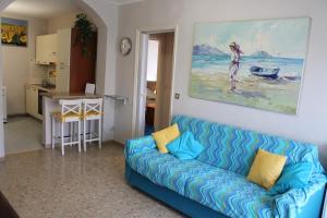 a living room with a blue couch and a kitchen at Favola Bella in Bardolino