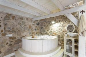a bathroom with a bath tub in a stone wall at Toscana Di Corvo in Moya +20 photos