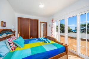 a bedroom with a colorful bed and a balcony at Luna in Cala d´Or +26 photos