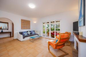 a living room with a couch and a chair at Luna in Cala d´Or
