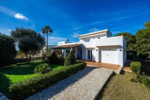 a white house with a garden and a driveway at Luna in Cala d´Or