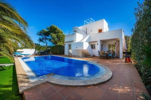 a villa with a swimming pool in front of a house at Luna in Cala d´Or
