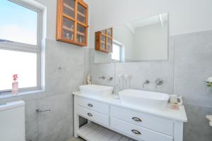 a white bathroom with a sink and a mirror at Our Father in Paternoster +97 photos