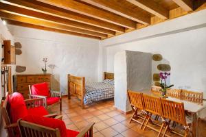 a living room with red chairs and a table at Mirador de Domingo in Gáldar