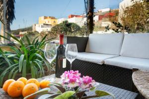 a table with a bottle of wine and a bunch of oranges at Mirador de Domingo in Gáldar +12 photos