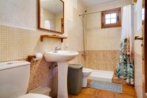 a bathroom with a sink and a toilet and a tub at Mirador de Domingo in Gáldar