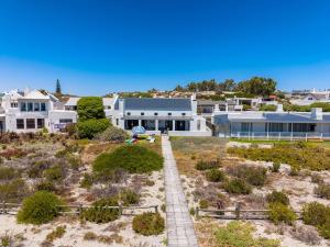 a house on the beach with a pathway in front of it at Our Father in Paternoster