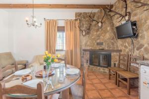 a living room with a table and a fireplace at Villa Conilsur in Conil de la Frontera