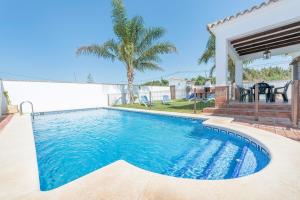 a swimming pool in the backyard of a house at Villa Conilsur in Conil de la Frontera