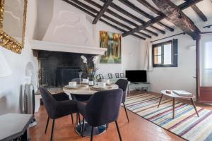 a living room with a table and chairs and a fireplace at Les 3 vues in Tourrettes-sur-Loup