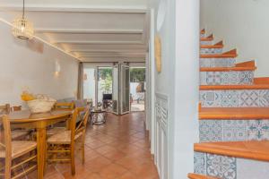 a kitchen and dining room with a table and a staircase at Arbocers in Ciutadella
