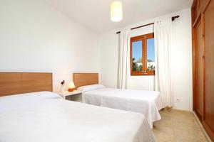 a white room with two beds and a window at Villa Animeta in Port de Pollensa +14 photos