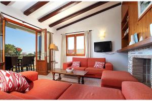 a living room with red furniture and a fireplace at Villa Animeta in Port de Pollensa