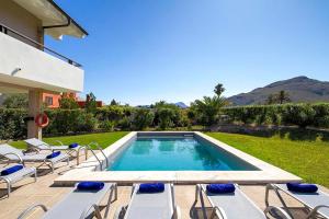 a swimming pool with lounge chairs next to a house at Villa Animeta in Port de Pollensa