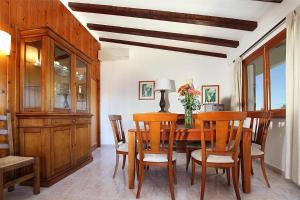 a dining room with a wooden table and chairs at Villa Animeta in Port de Pollensa