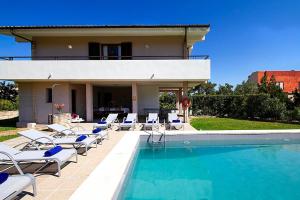 a swimming pool with chairs and a house at Villa Animeta in Port de Pollensa