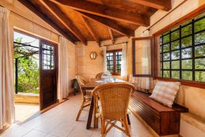 a dining room with a wooden table and chairs at Es Colomer in Petra