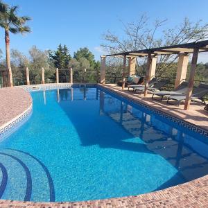 a swimming pool with chairs and a gazebo at Es Colomer in Petra