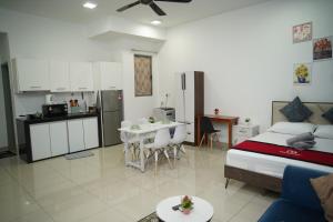 a bedroom with a bed and a kitchen with a table at Cozy Studio Netflix Parking Self Checkin Wifi free wifi 138 in Cyberjaya